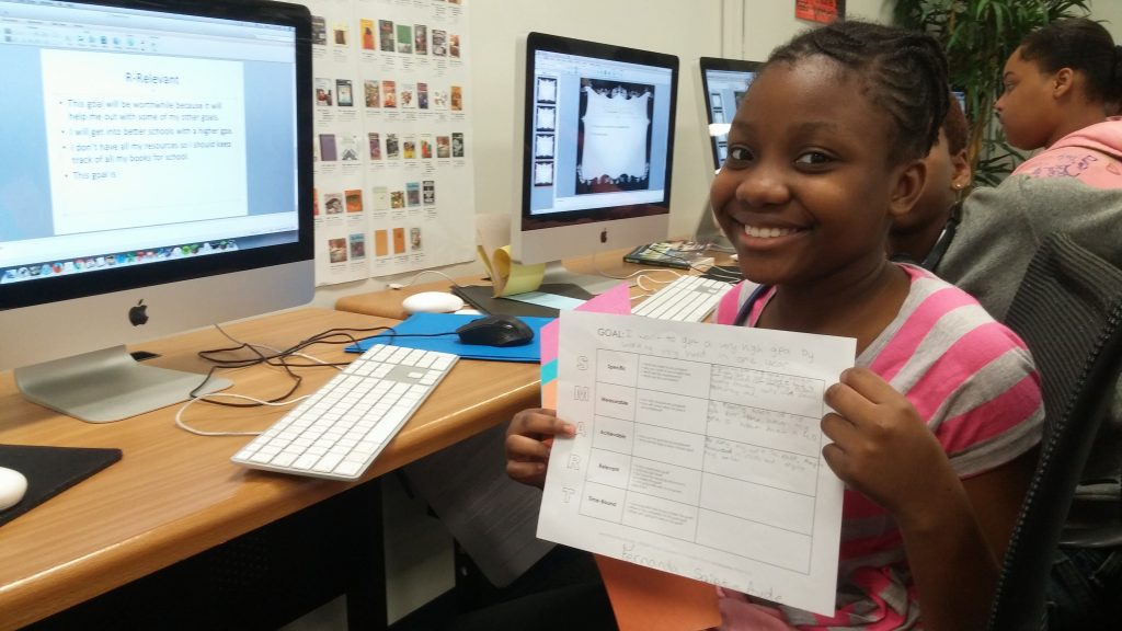 a student showing her goals printed on a paper