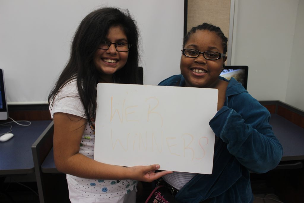 two Firewall Centers students holding a placard